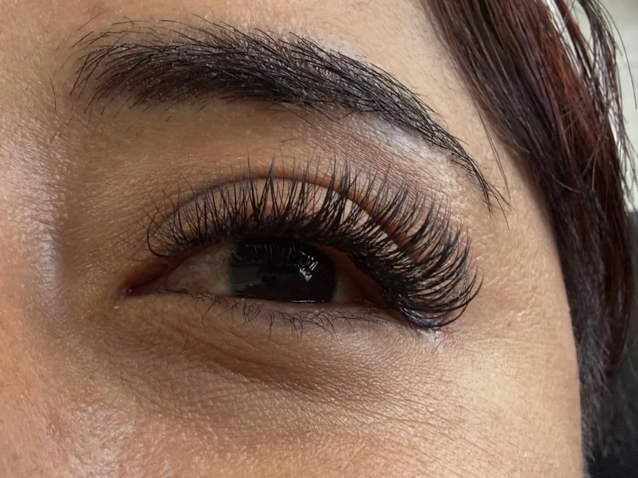 Diseño de mirada con aplicación de extensiones de pestañas y perfilado de cejas